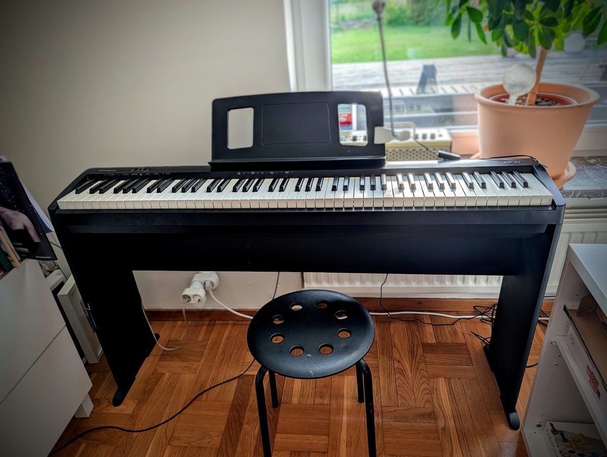 Roland FP-10 digital piano in black, slim profile on a stand