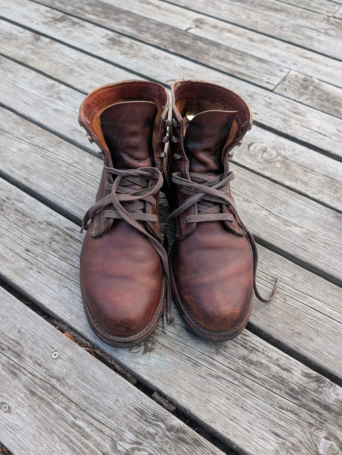 Wolverine 1000 Mile boots after thirteen years of wear, showing deep brown Chromexcel patina on a weathered wooden deck